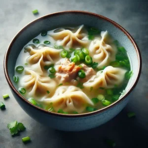 A bowl of wonton soup with plump dumplings, savory broth, and fresh green onions.