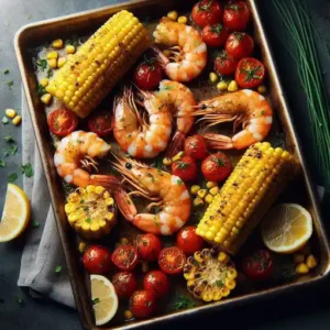 Sheet pan dinner with juicy shrimp, charred corn kernels, and burst tomatoes garnished with chives and lemon wedges